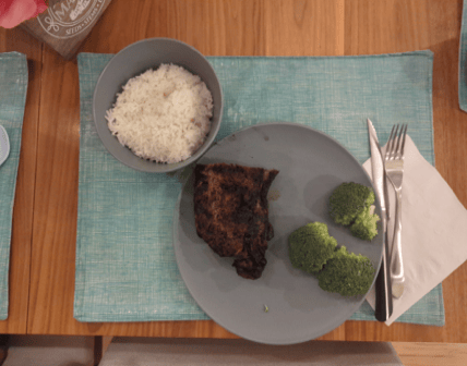 Client X's food-journal photo of a plate with meat, rice and broccoli