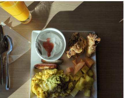 Client X's later food-journal breakfast photo with eggs, fruit and yogurt